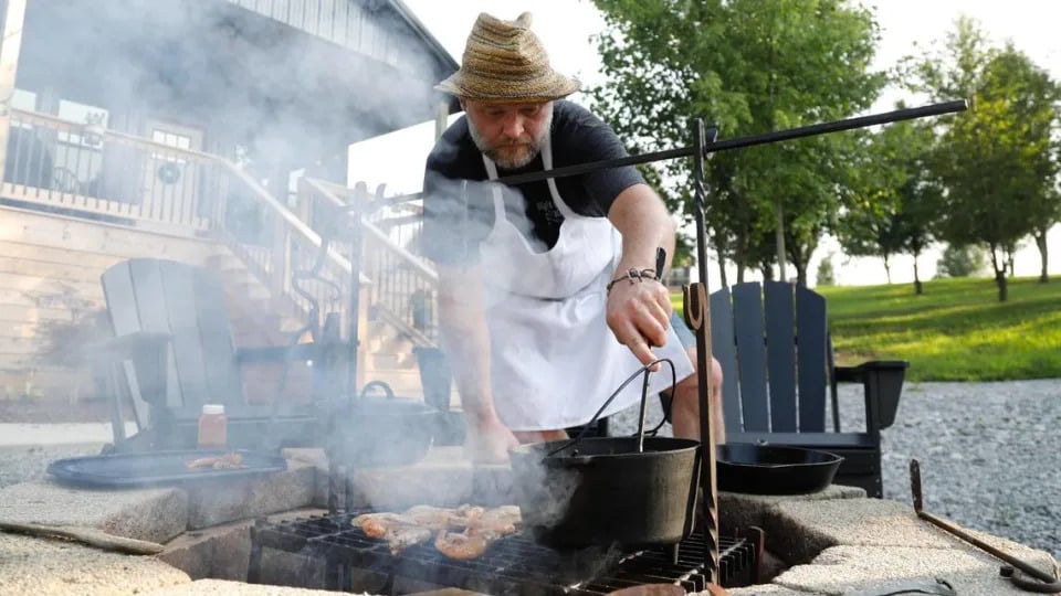 Tony Miller stirs butter, garlic and lemon juice that the prawns will be tossed once they are finished cooking on Tuesday, July 25, 2023 at Bourbon Barrel Cottages in Lawrenceburg, Ky.