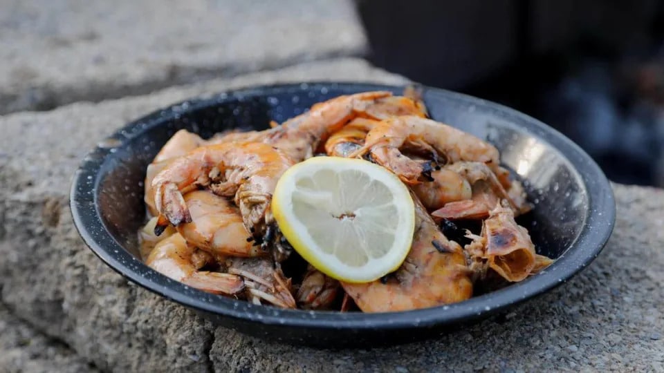 Fresh caught prawns from the Louisiana gulf tossed in olive oil and Cajun seasoning and grilled straight on the grate, then tossed in butter, garlic and lemon juice that has been cooked in a Dutch oven on Tuesday, July 25, 2023 at Bourbon Barrel Cottages in Lawrenceburg, Ky.